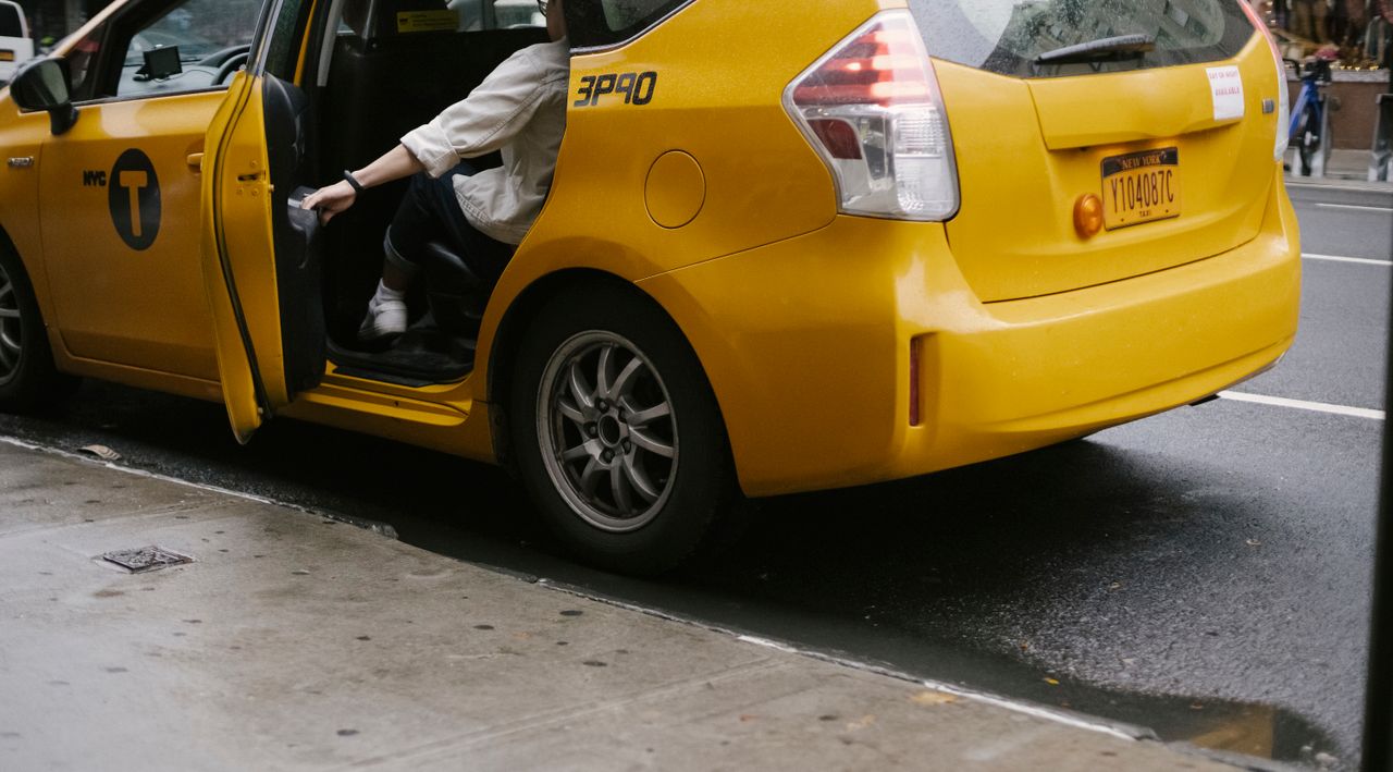 The Art of Drawing Readers In: Your attractive post title goes here Unrecognizable passenger closing door of yellow cab with logo and headlight parked on asphalt road near pavement on street in city